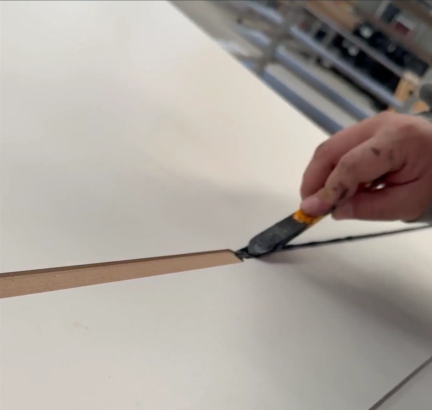 A worker applying a fine decorative line to a door panel by hand